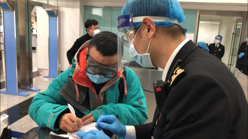 大连周水子机场海关关员在卫生检疫现场指导旅客填写健康申明卡 摄影：李洋